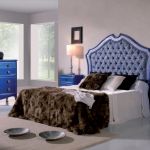 Dormitorio retro color azul profundo desgastado, con mesita de noche, cómoda y cabecero tapizado Dormitorio retro color azul profundo desgastado, con mesita de noche, cómoda y cabecero tapizado
