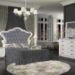 Dormitorio isabelino color blanco, con mesita de noche y cómoda. Cabecero tapizado en color gris. Dormitorio isabelino color blanco, con mesita de noche y cómoda. Cabecero tapizado en color gris.