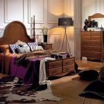 Dormitorio isabelino de color madera, con mesita de noche y cabecero clásico Dormitorio isabelino de color madera, con mesita de noche y cabecero clásico