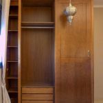 Interior de armario compuesto por barra para colgar ropa y balda para doblar. Cajonera de 3 cajones y altillo. Ventana salvada con zapatero menos profundo que el armario. Interior_armario_zapatero_cajones_barra_altillo