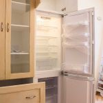 Detalle frigo integrable. Cocina blanco envejecida. Puertas de roble. frigo-abierto_encastrado_cocina_madera_beige