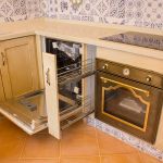 Detalle lavavajillas integrable y especiero. Cocina blanco envejecida. Puertas de roble. lavaplatos-y-especiero-abierto_cocina_madera_beige_envejecido