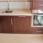 Detalle lavavajillas integrable. Cocina color nogal. Puertas de roble. Electrodomésticos Inox. lavavajillas_cocina_madera_puerta_cerrado