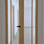 Puerta doble acristalada fabricada en madera maciza de roble con herrajes negros Puerta doble acristalada fabricada en madera maciza de roble con herrajes negros