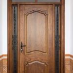 Portón de entrada de una puerta de serie, dos fijos laterales decorados con hierros negros y fijo superior de dos cristales mateados. Porton-entrada-rustico-san-juan-madera-forja