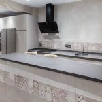 Cocina blanca con península. Electrodomésticos Inox y negros. Tirador uñero. Cocina-blanca-gola-barra-desayuno-campana-negra