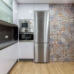 Cocina blanca en forma de U. Puerta laminada con tirador uñero. Electrodomésticos Inox y Negros. Cocina-blanca-gola-inox-encimera-gris