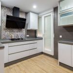 Cocina blanca en forma de U. Puerta laminada con tirador uñero. Electrodomésticos Inox y Negros. Cocina-blanca-gola-laminado-silestone-gris