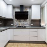 Cocina blanca en forma de U. Puerta laminada con tirador uñero. Electrodomésticos Inox y Negros. Cocina-blanca-gola-paralelo-extractor-negro