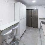 Cocina blanca. Puerta laminada. Tirador Gola. Electrodomésticos inox y negros. Cocina-blanco-brillo-gola-despensa-silestone-gris-oscuro