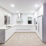 Cocina blanca. Puertas laminadas. Tirador Gola. Electrodomésticos blancos. Cocina-blanco-brillo-gola-forma-U-abierta-salon