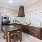 Cocina nogal oscuro. Puertas de Roble. Electrodomésticos Inox. Cocina-rustica-roble-nogal-mesa-sillas