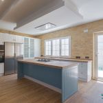 Cocina en forma de L con isla central en color blanco y azul Cocina en forma de L con isla central en color blanco y azul