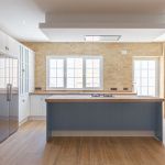 Cocina en forma de L con isla central en color blanco y azul Cocina en forma de L con isla central en color blanco y azul