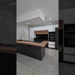 Cocina con península y encimera de porcelánico color grafito + barra de madera laminada Cocina con península y encimera de porcelánico color grafito + barra de madera laminada